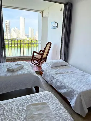 a room with two beds and a balcony with a view at Hermoso apartamento con vista en el laguito in Cartagena de Indias