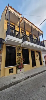 a yellow house with a balcony on a street at Casa Maguey – Refugio Tropical en el Centro de Cartagena in Cartagena de Indias