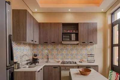 a kitchen with wooden cabinets and a sink at Casa Maguey – Refugio Tropical en el Centro de Cartagena in Cartagena de Indias