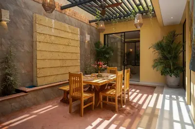 a patio with a wooden table and chairs at Casa Maguey – Refugio Tropical en el Centro de Cartagena in Cartagena de Indias