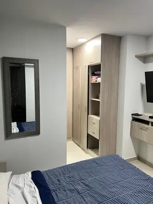 a bedroom with a bed and a mirror and a tv at Live in the Heights Fresh and Bright Apartment in Cartagena de Indias