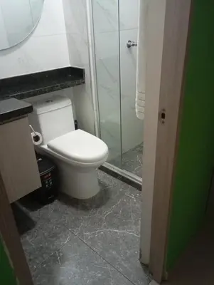 a bathroom with a toilet and a glass shower at Live in the Heights Fresh and Bright Apartment in Cartagena de Indias