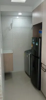 a small kitchen with a refrigerator and a trash can at Live in the Heights Fresh and Bright Apartment in Cartagena de Indias