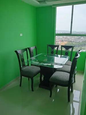 a green dining room with a glass table and chairs at Live in the Heights Fresh and Bright Apartment in Cartagena de Indias