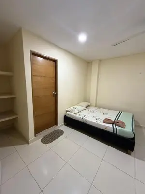 a small bedroom with a bed and a wooden door at Villa Ana tu hogar lejos de casa in Coveñas