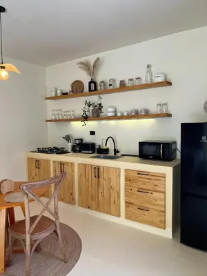 a kitchen with wooden cabinets and a black refrigerator at Villa Privada con Piscina - Playas del Atlantico in Tubará