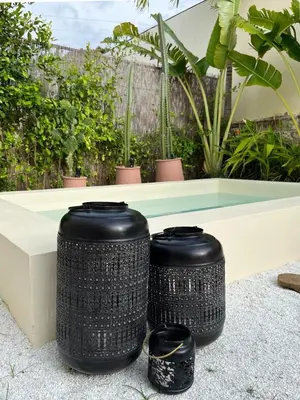 two black wicker trash cans sitting next to a bench at Villa Privada con Piscina - Playas del Atlantico in Tubará