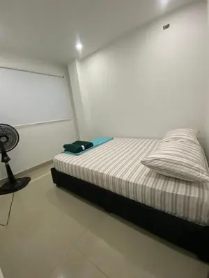 a bedroom with a bed with a pillow and a fan at Apartamento para Grupos En La Boquilla BBB in Cartagena de Indias