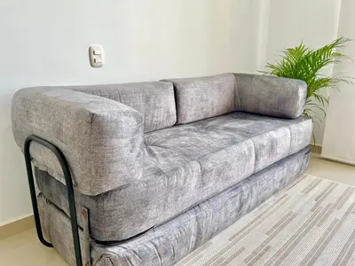 a grey couch in a living room with a plant at Relax with a views, massage chairs and coffee station in Barranquilla