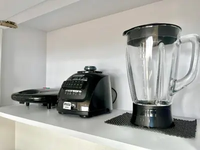 a blender sitting on a shelf next to a phone at Relax with a views, massage chairs and coffee station in Barranquilla