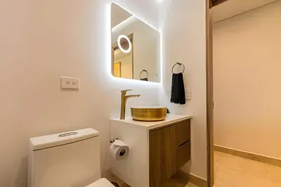 a bathroom with a toilet and a sink and a mirror at Nueva, Lujosa y Exclusiva Suite Vista al Mar in Cartagena de Indias