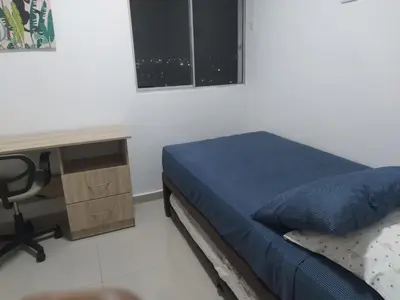 a bedroom with a desk and a bed with a blue blanket at VISTA CARIBE- apartamento piso 25, marbella in Cartagena de Indias