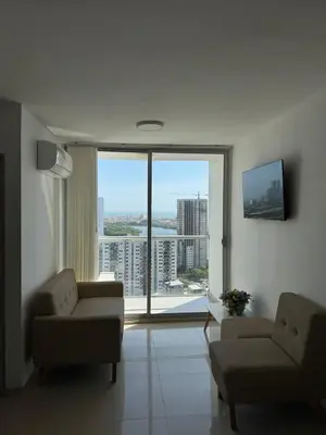 a living room with two chairs and a large window at VISTA CARIBE- apartamento piso 25, marbella in Cartagena de Indias