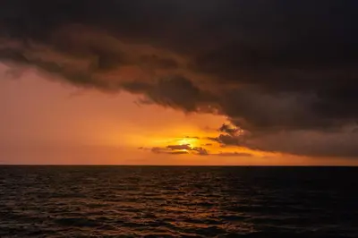 a sunset over the ocean with a storm cloud at CARDUMEN Arte y Cocina in Playa Blanca