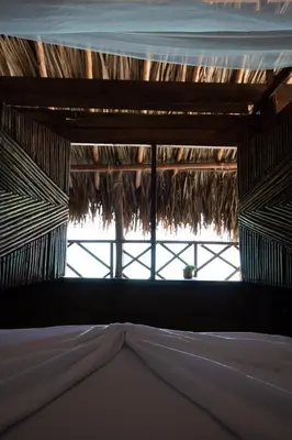 a view of a bed in a thatched room at CARDUMEN Arte y Cocina in Playa Blanca