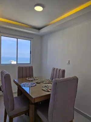 a dining room with a wooden table and chairs at Alojamiento Nuevo en Piso 24 con WiFi Rápido y Vista al Mar, Cerca al Centro Histórico in Cartagena de Indias