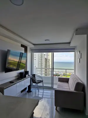 a living room with a couch and a desk with a view of the ocean at Alojamiento Nuevo en Piso 24 con WiFi Rápido y Vista al Mar, Cerca al Centro Histórico in Cartagena de Indias