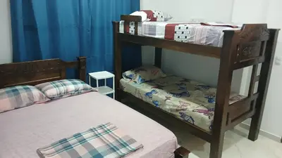 two bunk beds in a room with blue curtains at Hospedaje MangleRojo - Cerca al Mar in Coveñas