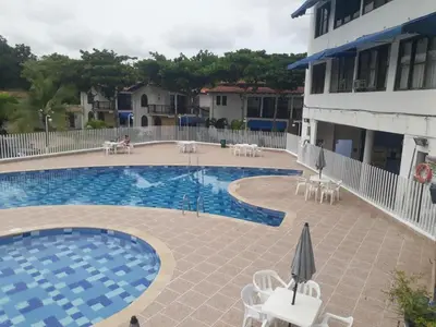 a pool with chairs and umbrellas next to a building at Victoria Real in Coveñas