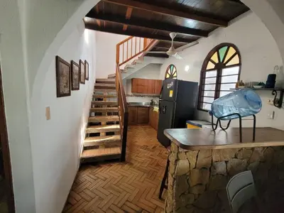 a room with a staircase and a kitchen with a stair case at Victoria Real in Coveñas