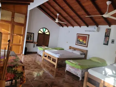 a room with three beds and a ceiling at Victoria Real in Coveñas