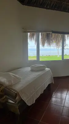 a bedroom with a bed with a large window at Punta Manzanillo in San Bernardo del Viento