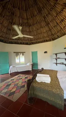 a bedroom with two beds and a thatched roof at Punta Manzanillo in San Bernardo del Viento