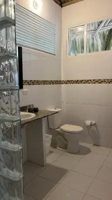 a white bathroom with a toilet and a sink at Punta Manzanillo in San Bernardo del Viento