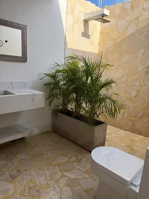 a bathroom with a toilet and a potted plant at Luxury Suite frente de Mar Piscina Restaurante y Bar in San Silvestre