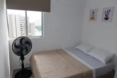 a bedroom with a bed with a fan and a window at Piso 32 Vista al mar y centro histórico in Cartagena de Indias