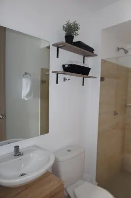 a bathroom with a toilet and a sink and a mirror at Piso 32 Vista al mar y centro histórico in Cartagena de Indias