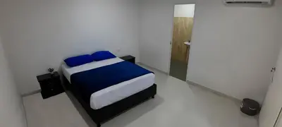 a bedroom with a bed in a white room at Hotel Roy in Santa Marta