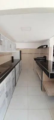 a kitchen with white cabinets and a black counter top at Hotel Roy in Santa Marta