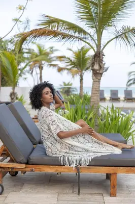 a woman sitting on a lounge chair at the beach at Apartamento Morros 3 Cartagena, Piscina Playa y Mar in Cartagena de Indias