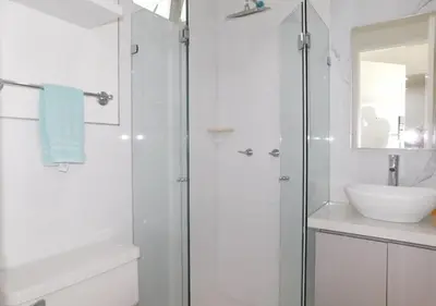 a white bathroom with a shower and a sink at Apartamento Morros 3 Cartagena, Piscina Playa y Mar in Cartagena de Indias