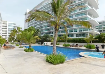 a palm tree in front of a large building at Apartamento Morros 3 Cartagena, Piscina Playa y Mar in Cartagena de Indias