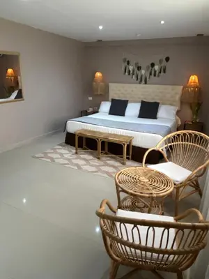 a bedroom with a bed and a table and chairs at Dorado Beach Isla in Playa Punta Arena