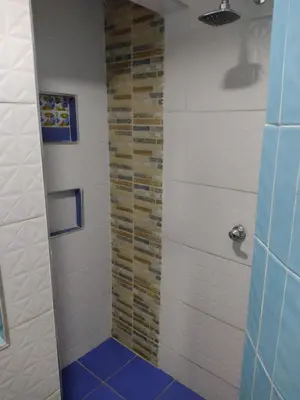 a bathroom with a shower with a blue floor at Casa Angie in Cartagena de Indias