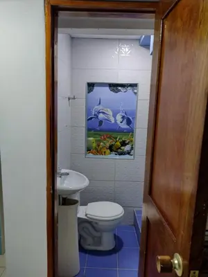 a bathroom with a toilet and a painting on the wall at Casa Angie in Cartagena de Indias