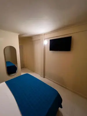 a bedroom with a blue bed and a mirror at Alma Del Mar in Cartagena de Indias