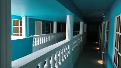 a hallway of a blue building with a white railing at Alma Del Mar in Cartagena de Indias