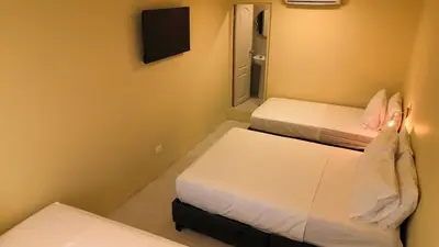 a small room with two beds and a mirror at Alma Del Mar in Cartagena de Indias
