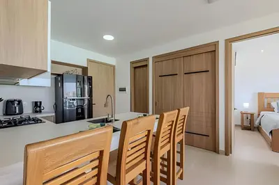 a kitchen with wooden cabinets and chairs in a room at Vista a Laguna cristalina + 2 alc + parking in Cartagena de Indias