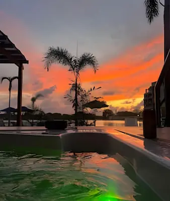 a swimming pool with a sunset in the background at Vista a Laguna cristalina + 2 alc + parking in Cartagena de Indias