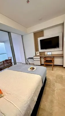a hotel room with a bed and a flat screen tv at Sunset Loft frente al mar CB1506 in Cartagena de Indias