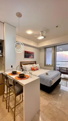 a bedroom with a bed and a kitchen with a table at Sunset Loft frente al mar CB1506 in Cartagena de Indias