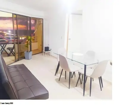 a dining room with a glass table and white chairs at apto cartagena con vista al mar 11 in Cartagena de Indias