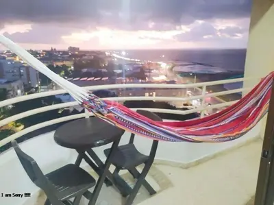 a hammock on a balcony with a table and chairs at apto cartagena con vista al mar 11 in Cartagena de Indias