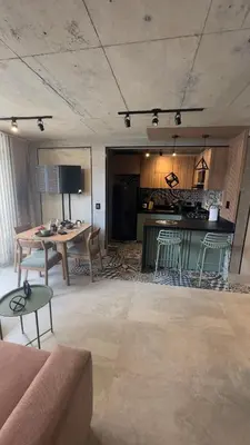 a living room with a table and a kitchen at Barranquilla Dreams in Puerto Colombia