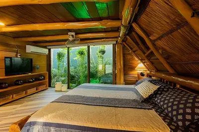 a bedroom with a large bed and a large window at Tita Tati Disconnect near Cartagena in Punta Canoas